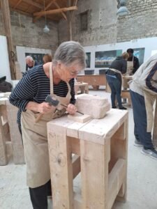 Groupe de personnes âgés en train de s'initier à la sculpture sur pierre à la Maison de la Pierre à Saint-Maximin